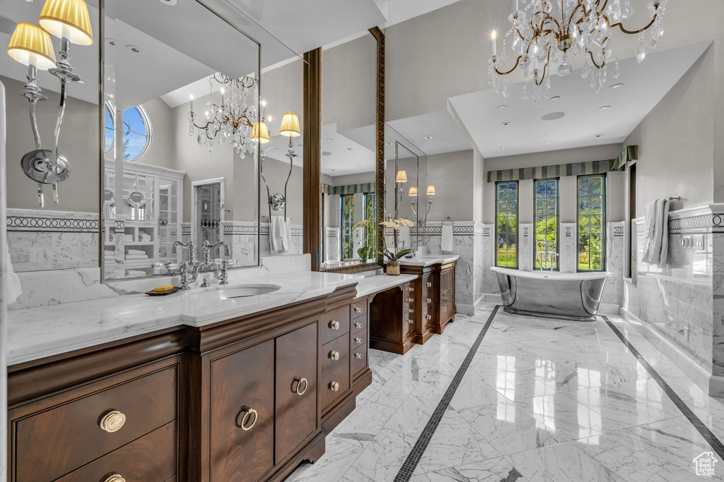 Bathroom with a bathing tub, vanity, a healthy amount of sunlight, and a high ceiling