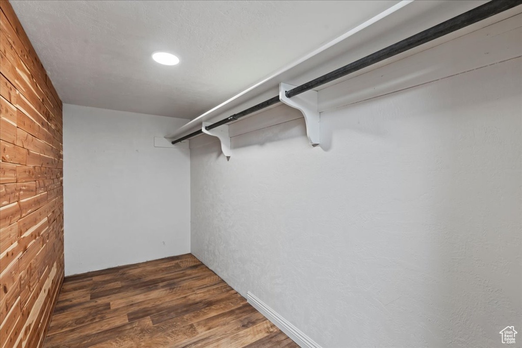 Walk in closet featuring dark wood-type flooring