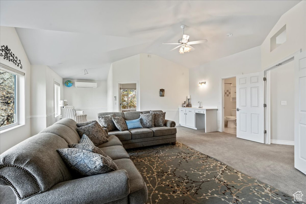 Carpeted living room with vaulted ceiling, an AC wall unit, a wealth of natural light, and ceiling fan