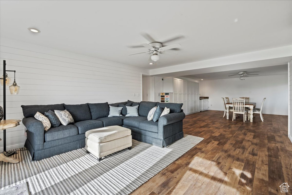 Living room with ceiling fan and dark hardwood / wood-style flooring