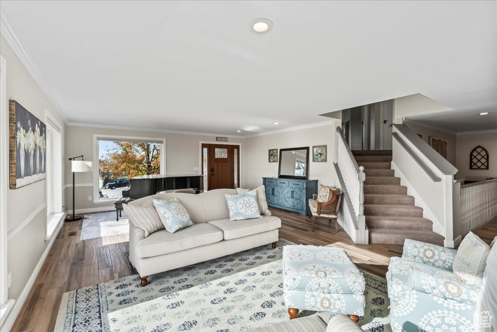 Living room with wood-type flooring and ornamental molding