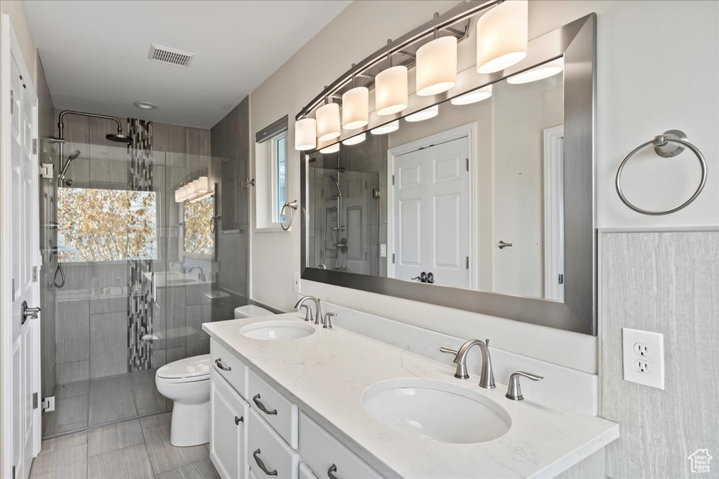 Bathroom featuring toilet, vanity, and walk in shower