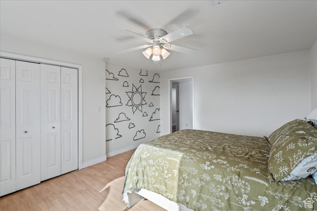 Bedroom featuring ceiling fan, a closet, and wood-type flooring