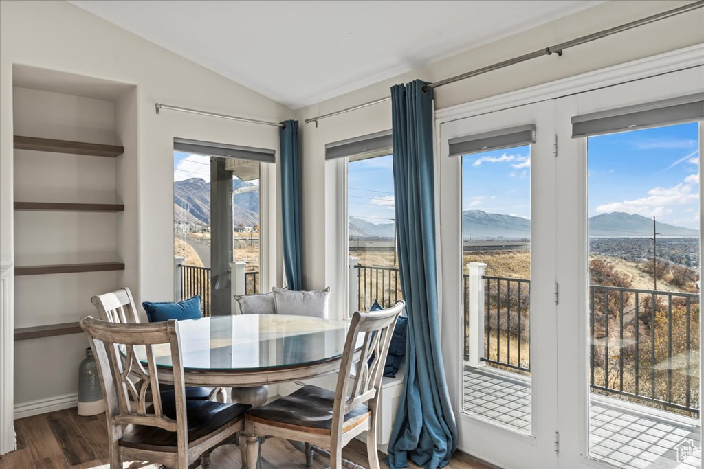 Dining area featuring hardwood / wood-style flooring, plenty of natural light, a mountain view, and lofted ceiling