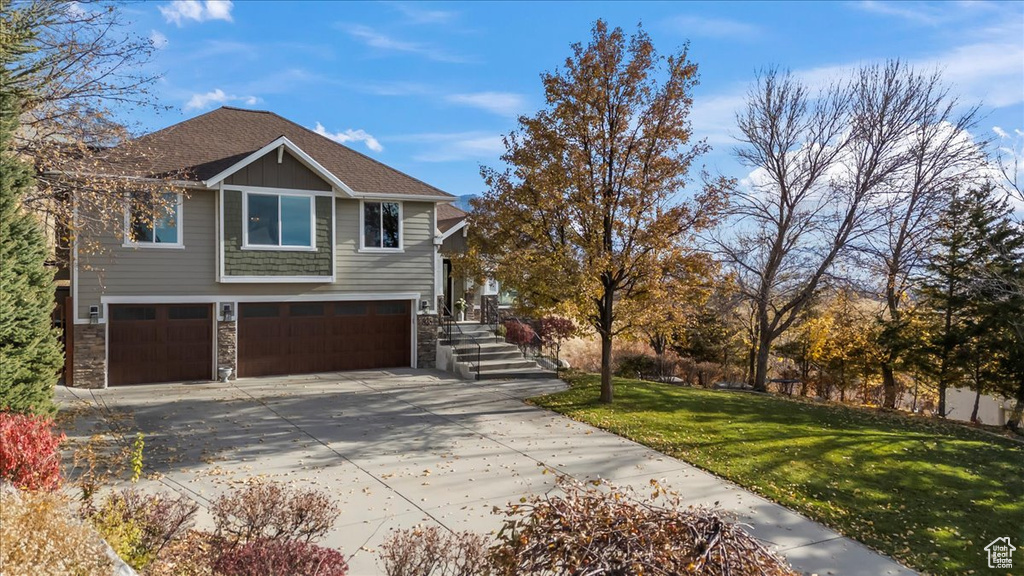 View of front of house featuring a front lawn and a garage