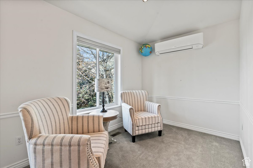 Living area featuring carpet floors and a wall unit AC