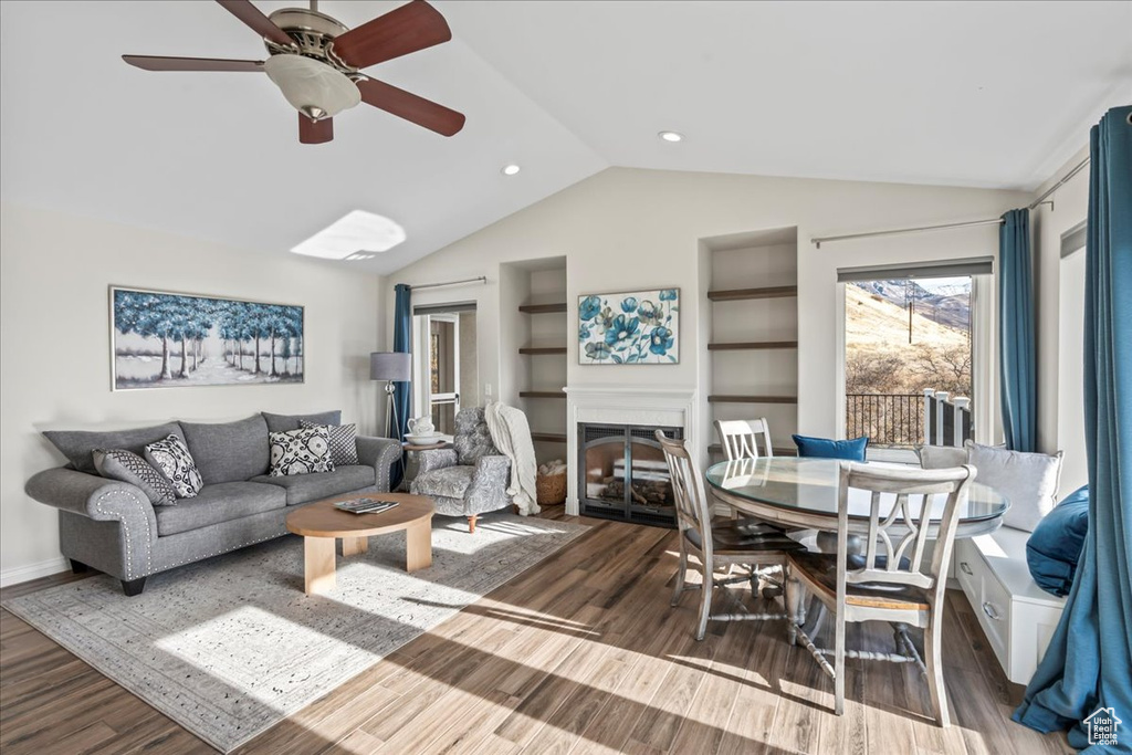 Living room featuring ceiling fan, dark wood-type flooring, and lofted ceiling