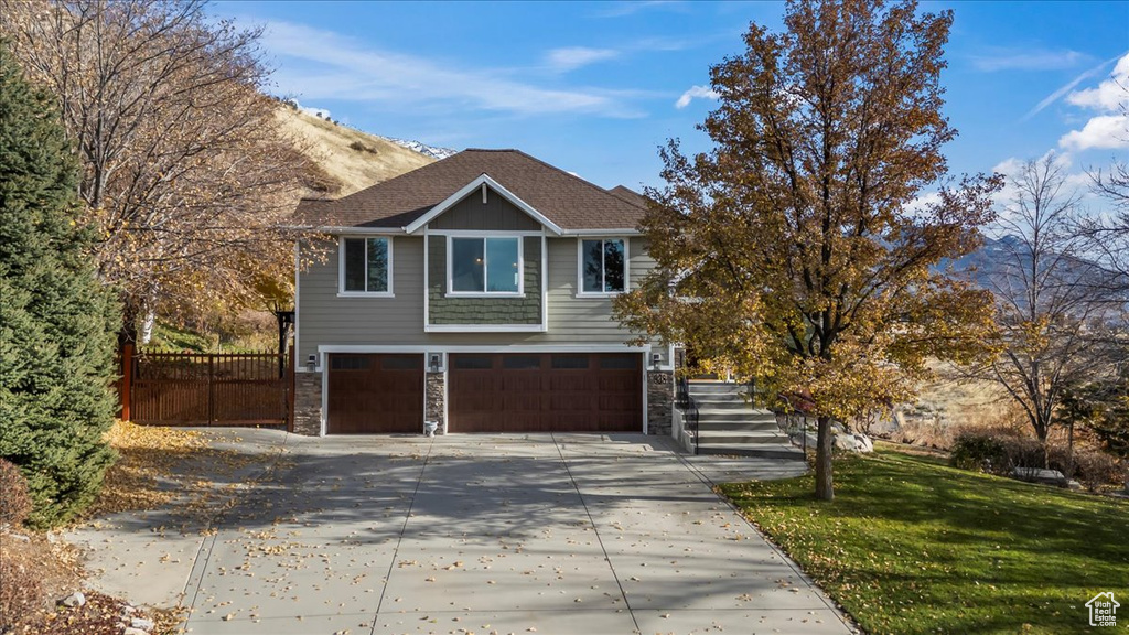 View of front of home with a garage and a front lawn