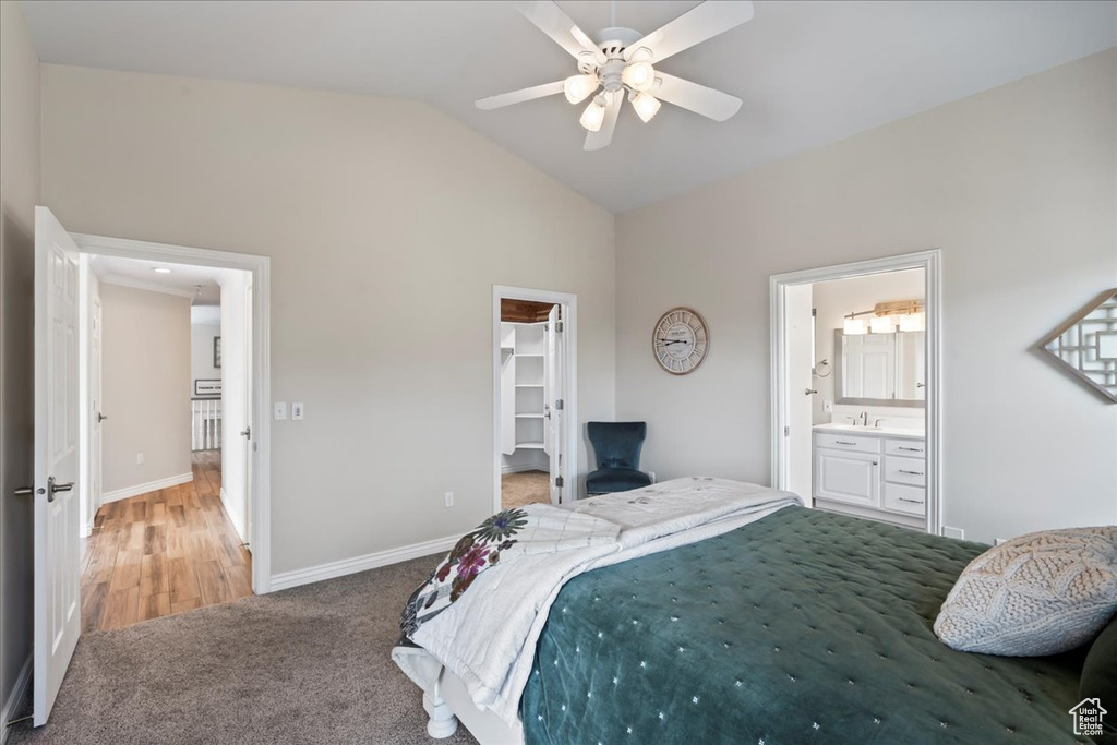 Bedroom featuring a walk in closet, ceiling fan, connected bathroom, a closet, and lofted ceiling