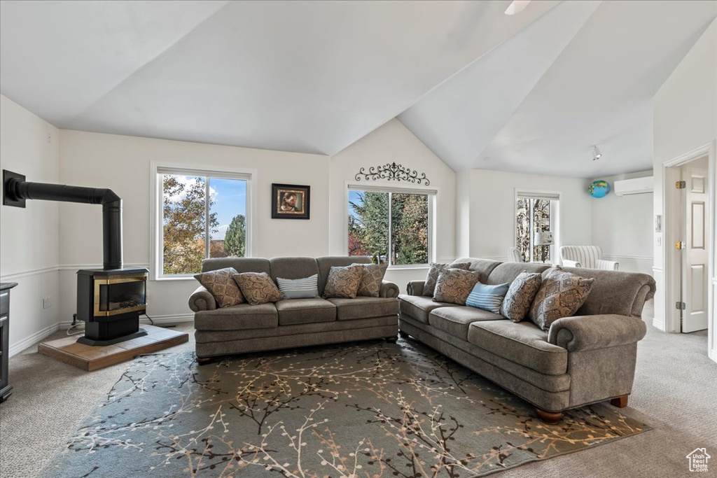 Carpeted living room with an AC wall unit, a wood stove, and lofted ceiling