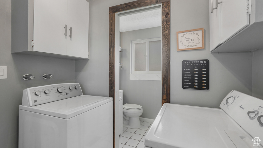 Laundry area featuring separate washer and dryer and light tile patterned floors