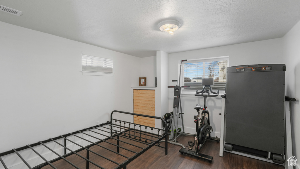 Exercise area featuring a textured ceiling and dark hardwood / wood-style floors