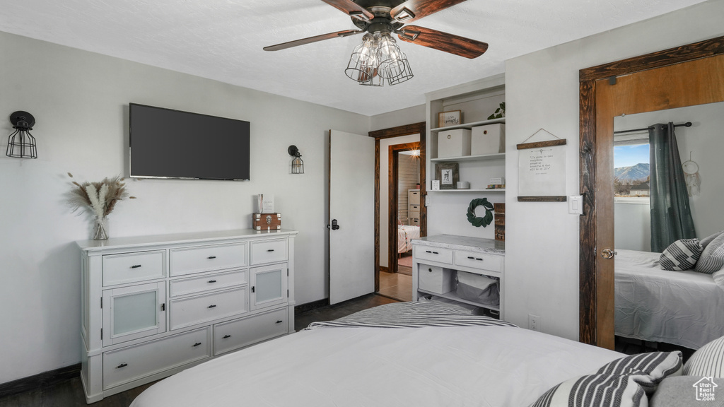 Bedroom with ceiling fan and dark wood-type flooring