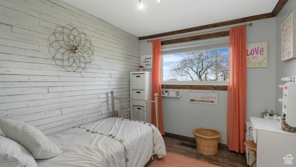 Bedroom featuring dark hardwood / wood-style flooring and wooden walls