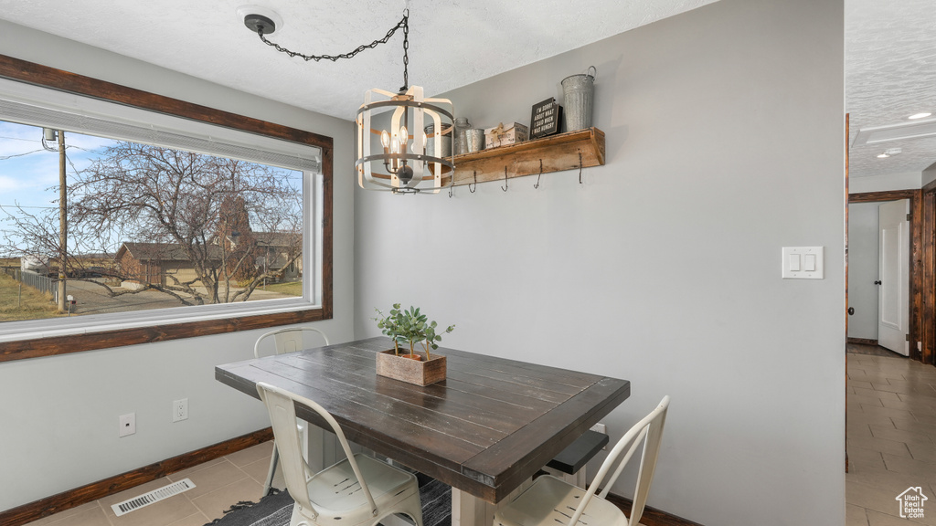 Tiled dining space with an inviting chandelier