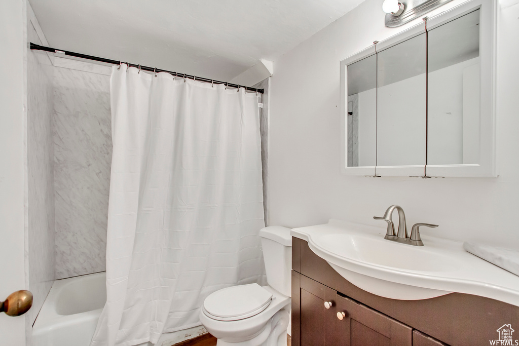 Full bathroom with shower / tub combo, vanity, and toilet