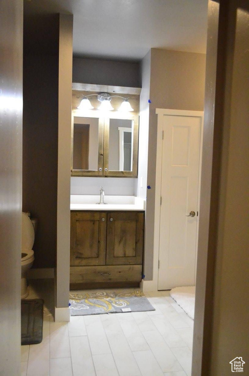 Bathroom with tile patterned flooring, vanity, and toilet