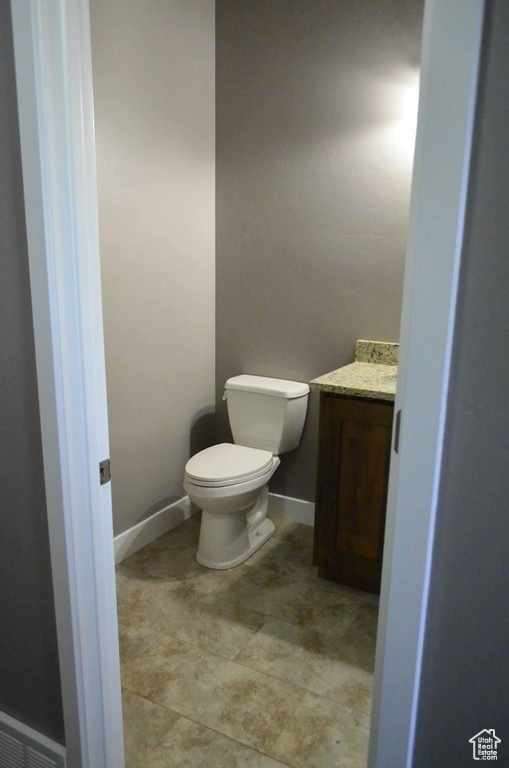 Bathroom featuring tile patterned floors, toilet, and vanity