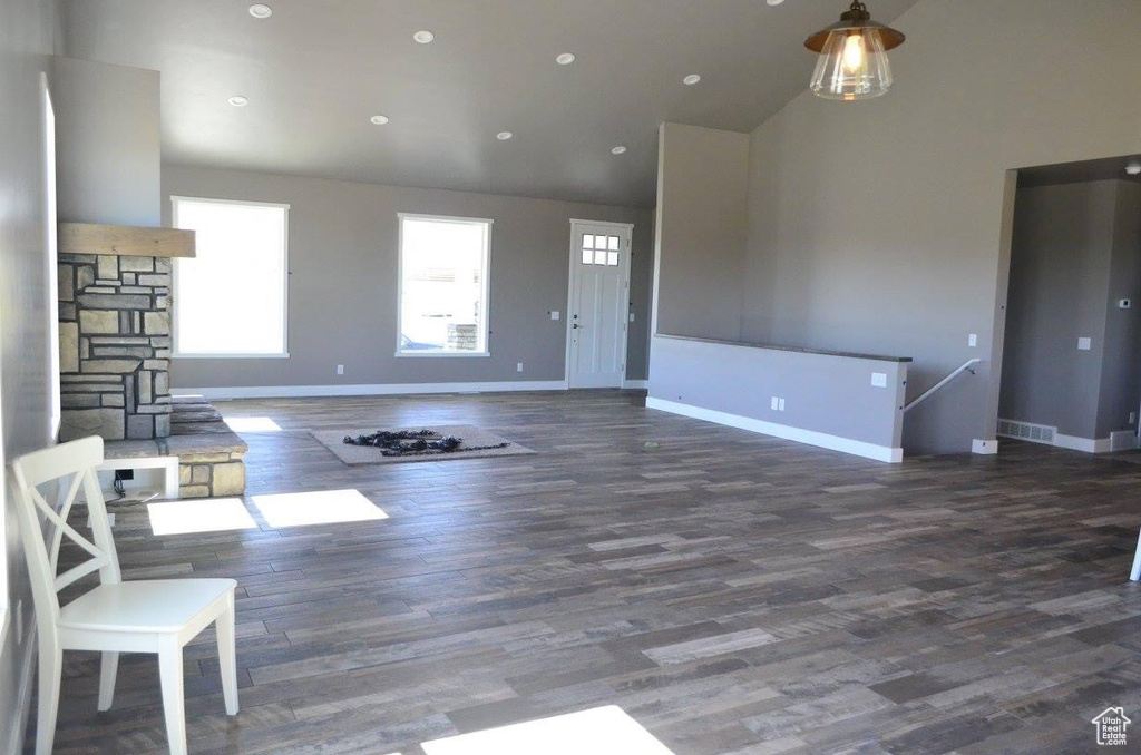 Unfurnished living room with a high ceiling and dark hardwood / wood-style flooring