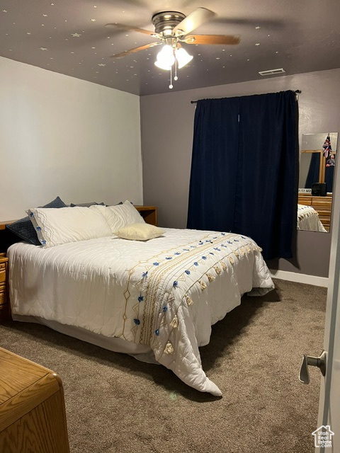 Bedroom featuring ceiling fan and carpet floors