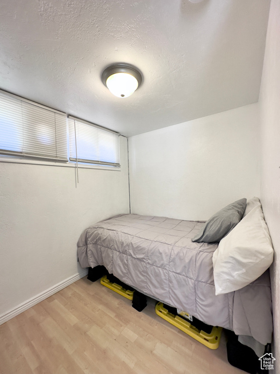 Bedroom with hardwood / wood-style floors and a textured ceiling