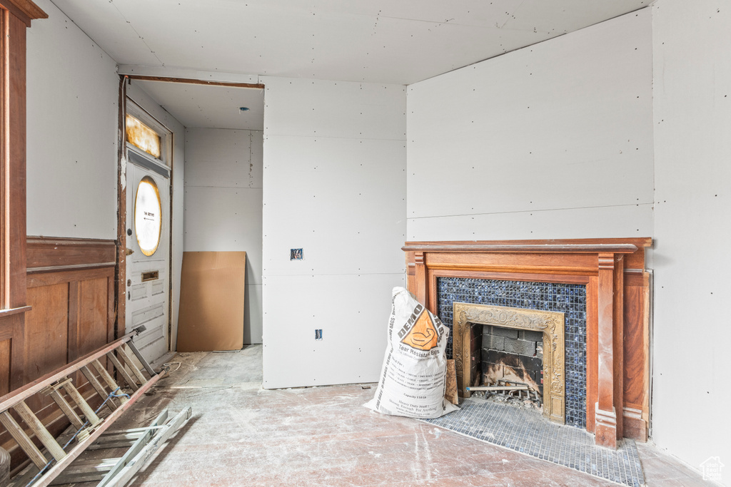 Unfurnished living room featuring a tiled fireplace