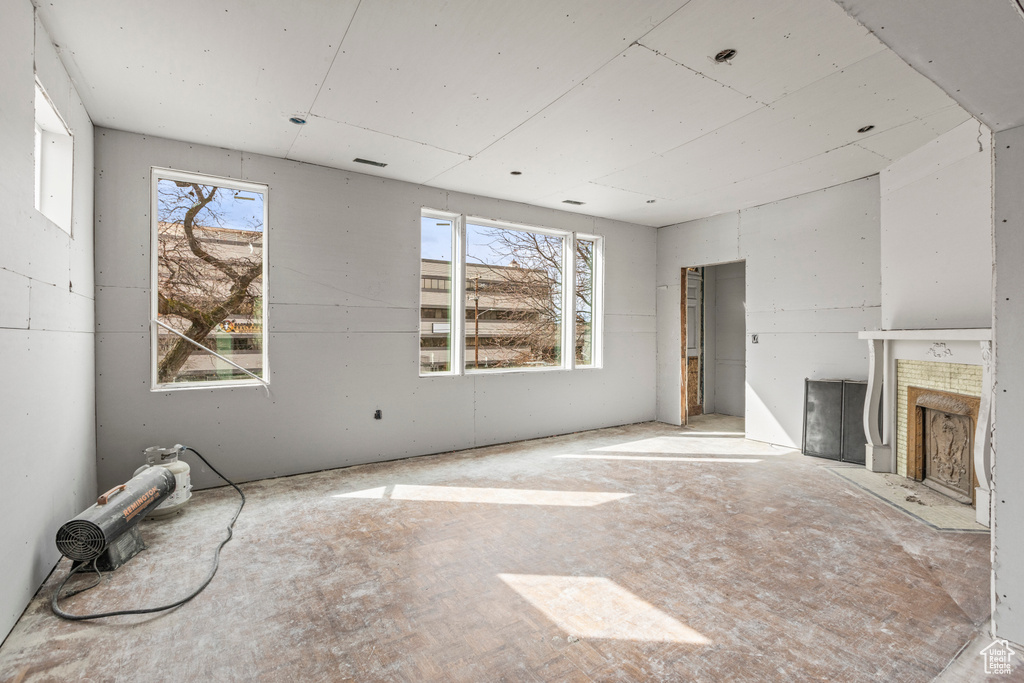 Unfurnished living room with plenty of natural light and a fireplace