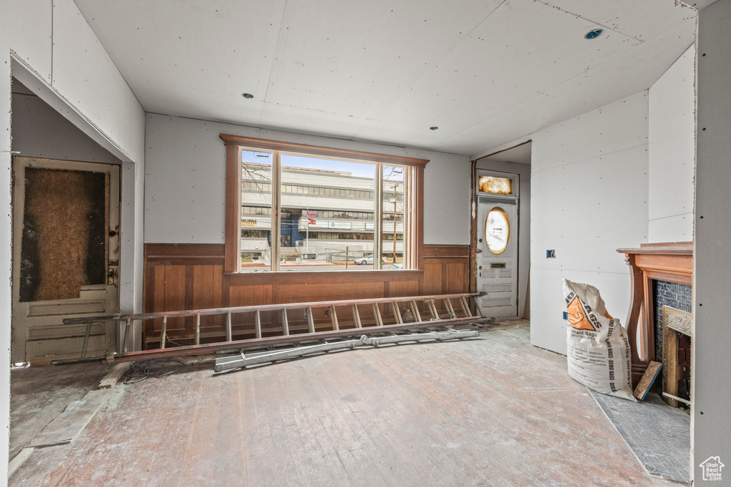 Unfurnished living room featuring a wainscoted wall and hardwood / wood-style flooring