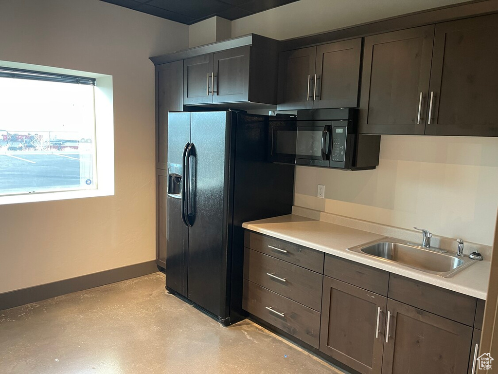 Kitchen featuring black appliances, dark brown cabinets, and sink