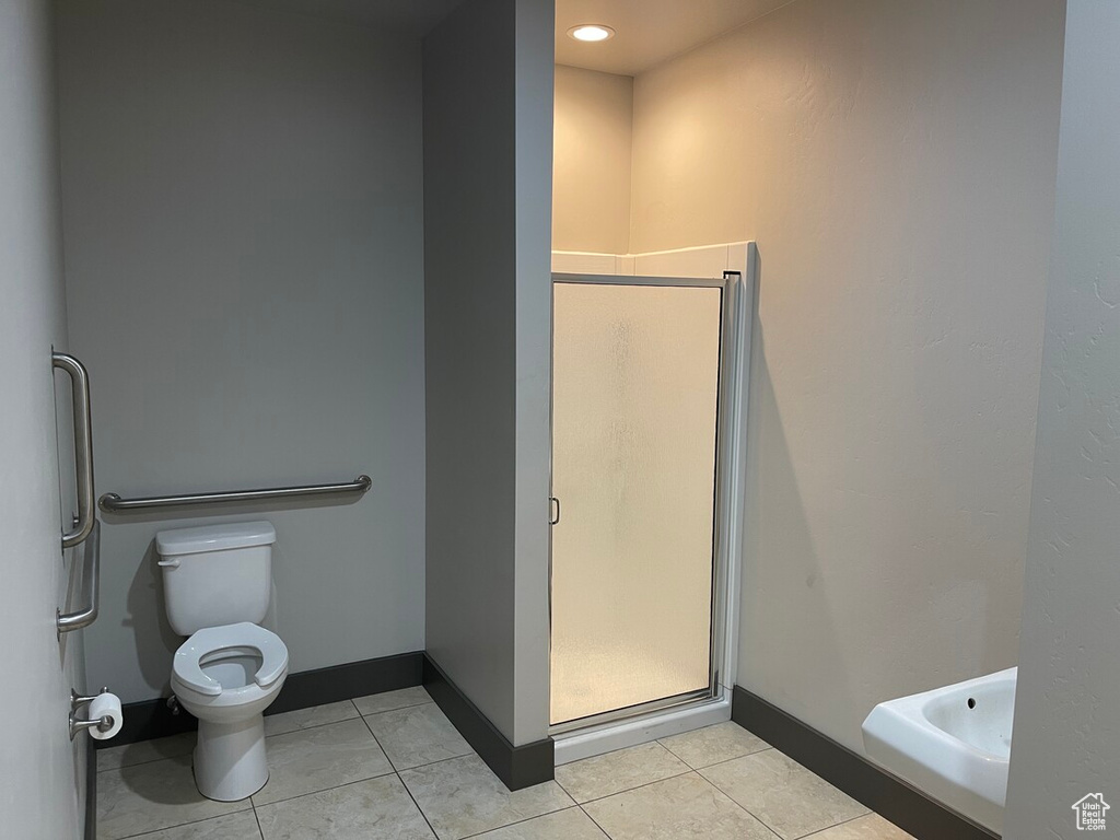 Bathroom with tile patterned flooring, toilet, and walk in shower