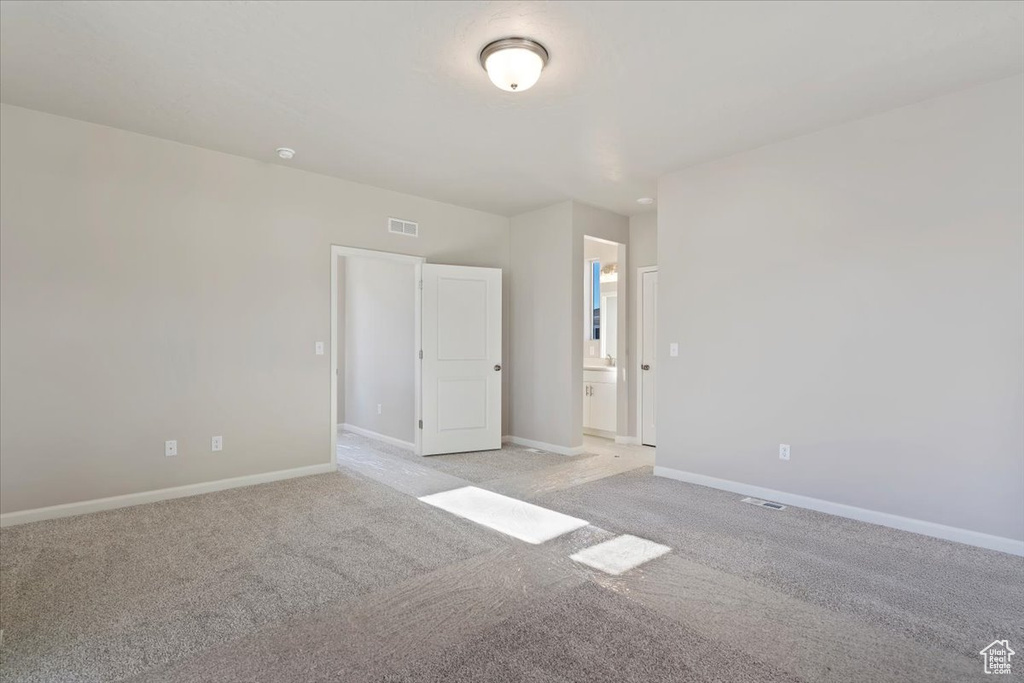 Interior space featuring baseboards, light colored carpet, and visible vents