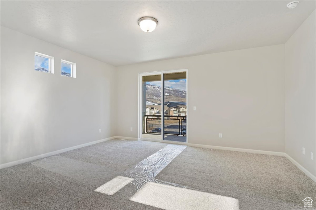 Empty room featuring carpet floors and baseboards