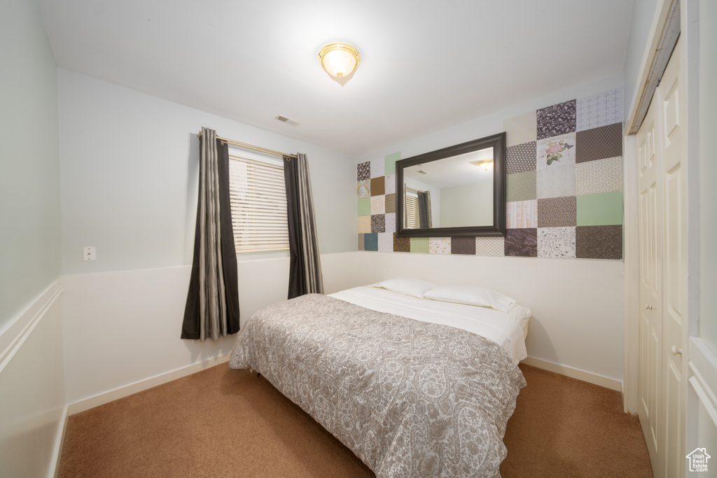 Carpeted bedroom with a closet