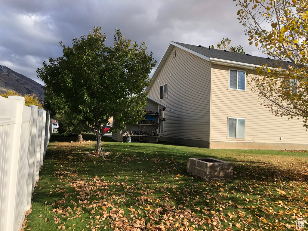 View of property exterior featuring a mountain view and a yard