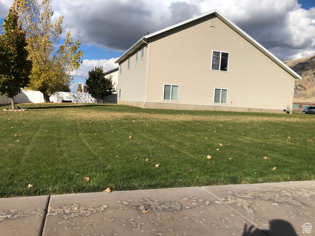 View of side of home featuring a yard