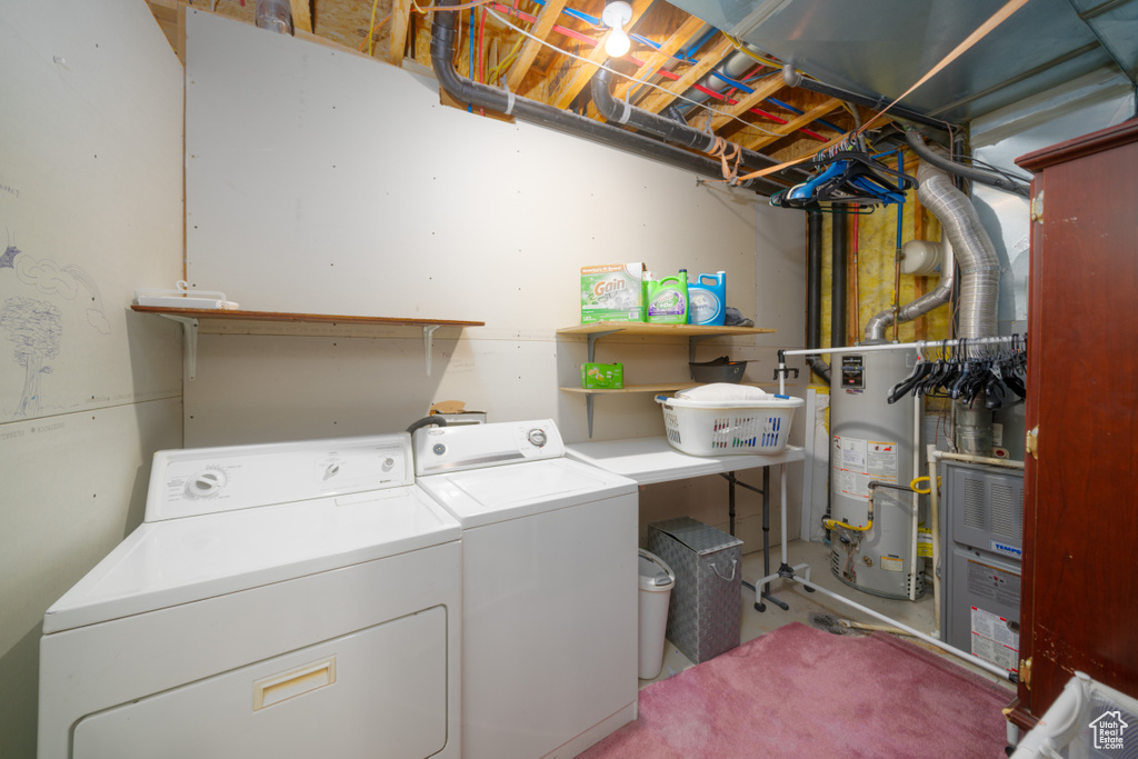 Laundry room featuring washing machine and clothes dryer and water heater