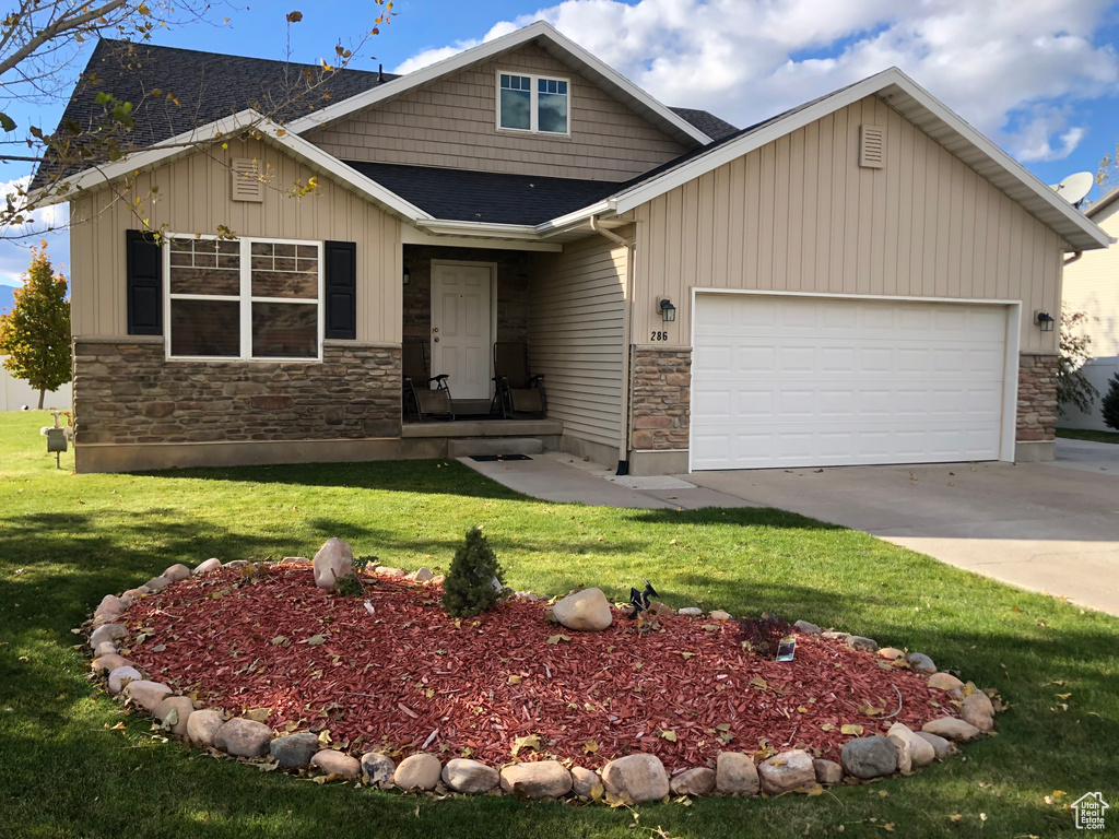 Craftsman inspired home with a front yard and a garage