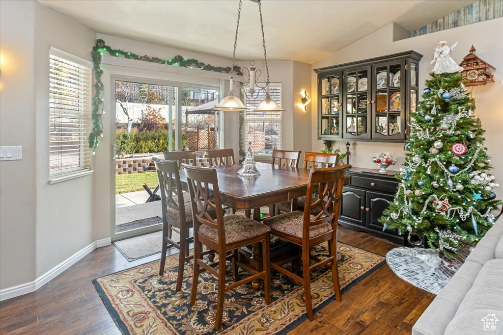 Dining area with dark wood-type flooring and vaulted ceiling