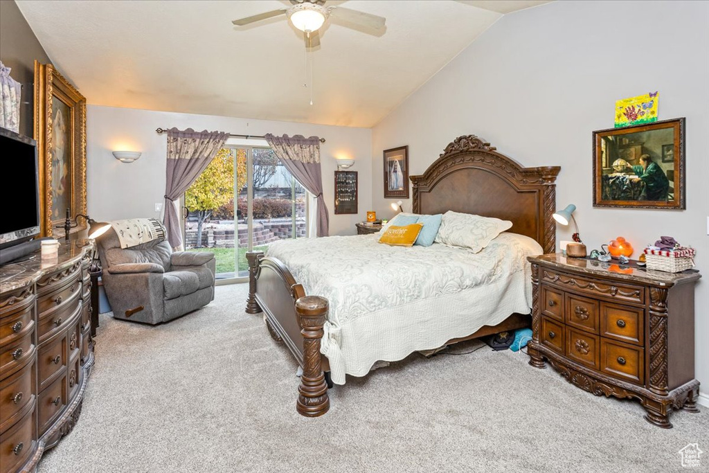 Bedroom with access to exterior, light carpet, vaulted ceiling, and ceiling fan