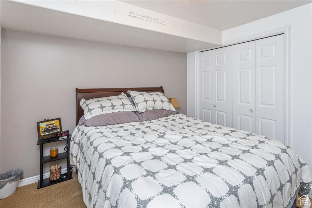 Bedroom featuring light carpet and a closet