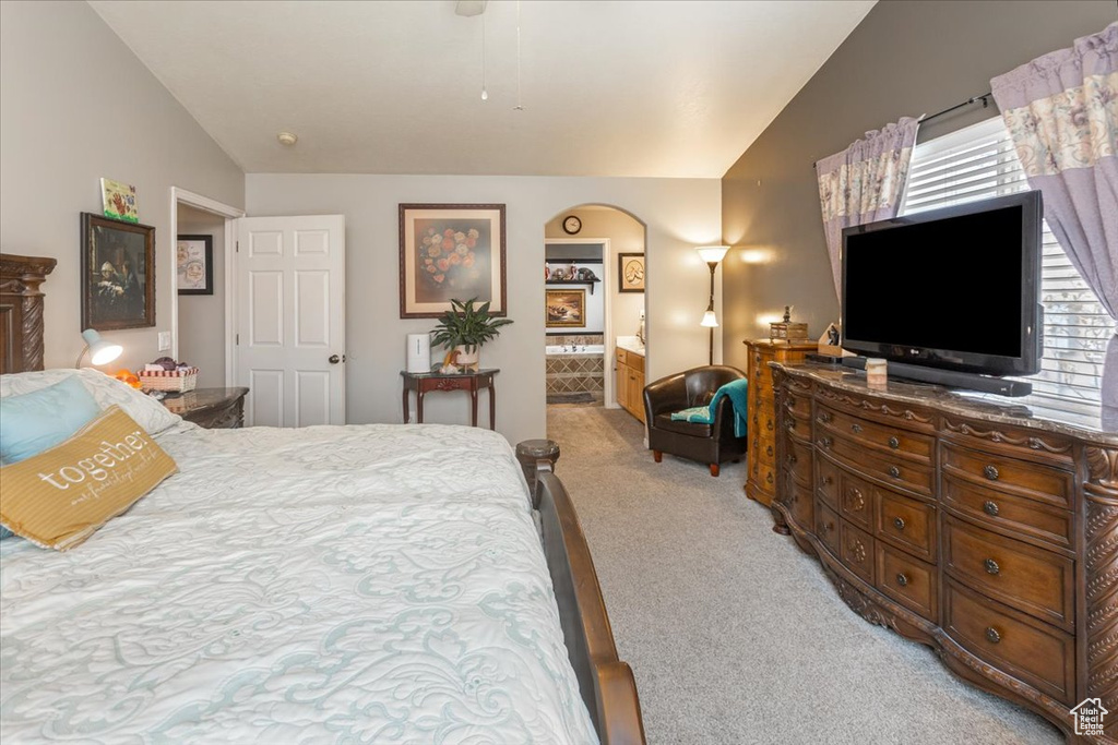 Bedroom with multiple windows, light carpet, and lofted ceiling