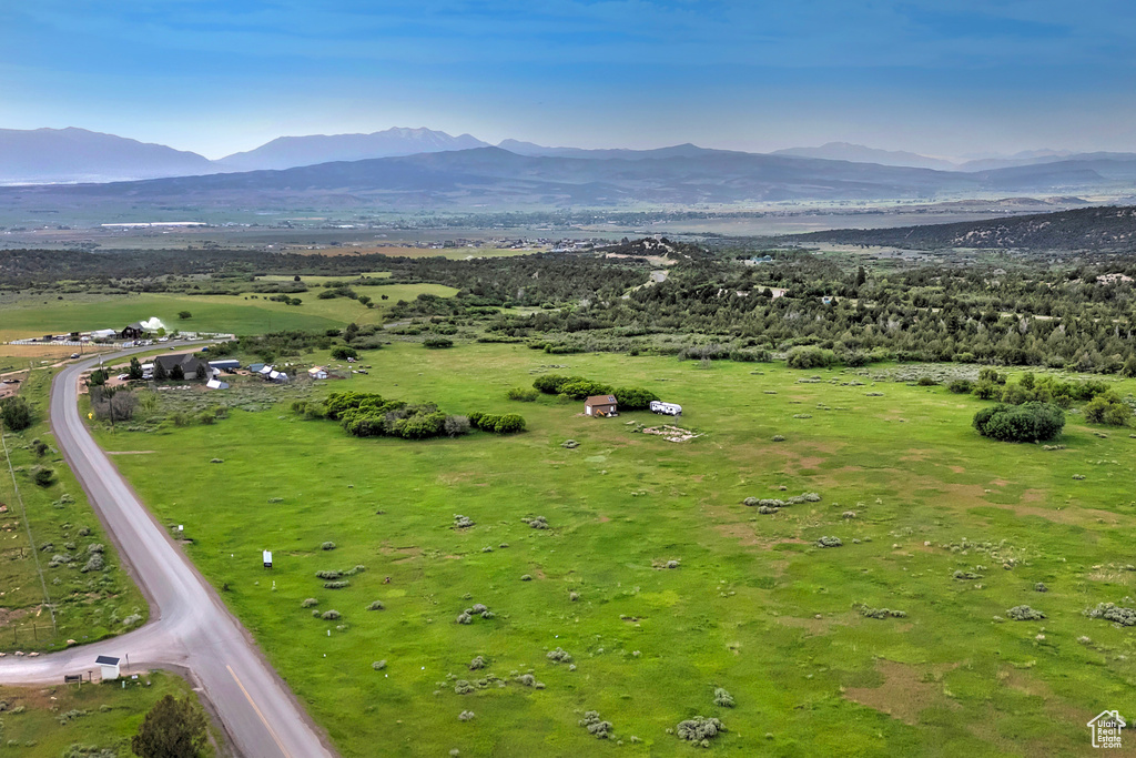 Aerial view of property and surrounding area with a mountain backdrop