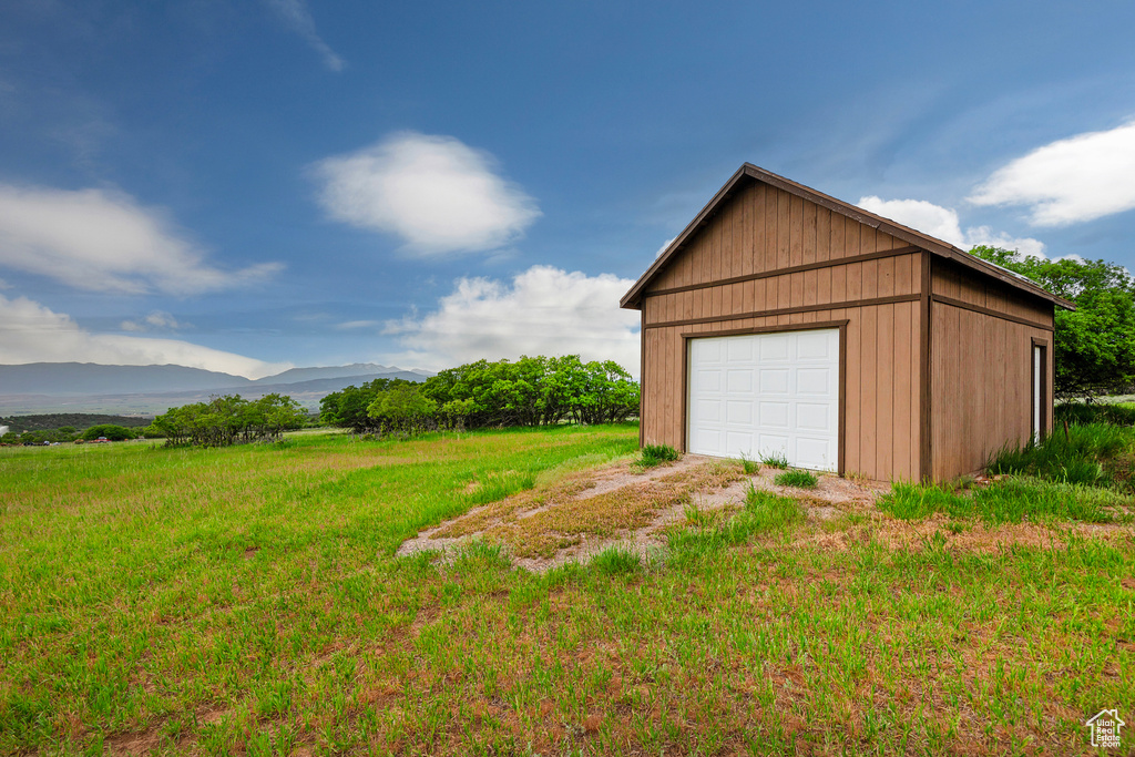 Detached garage featuring a mountain view and driveway