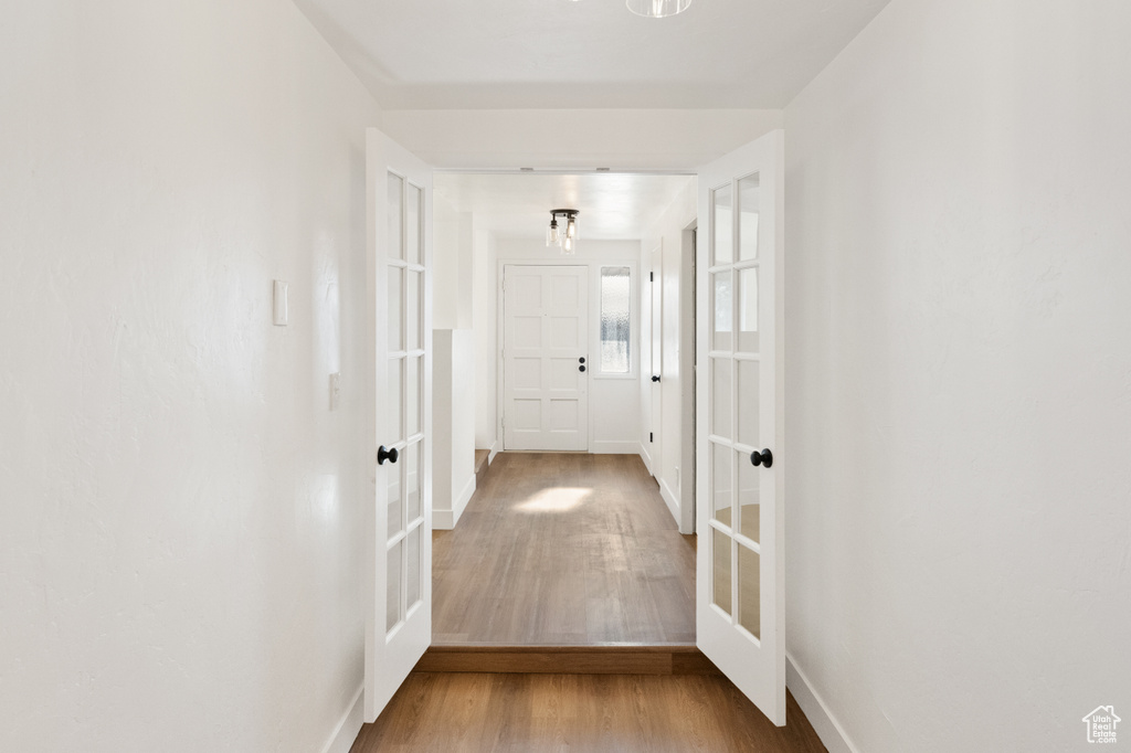 Hallway with french doors and hardwood / wood-style flooring