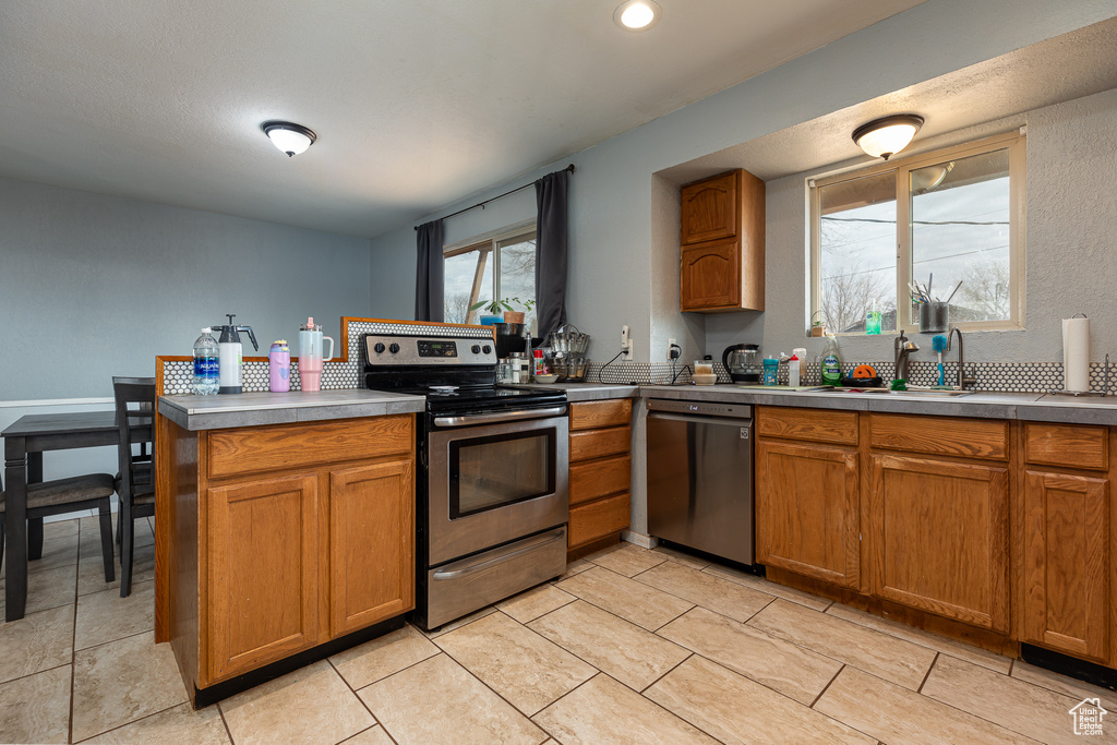 Kitchen featuring kitchen peninsula, appliances with stainless steel finishes, and sink