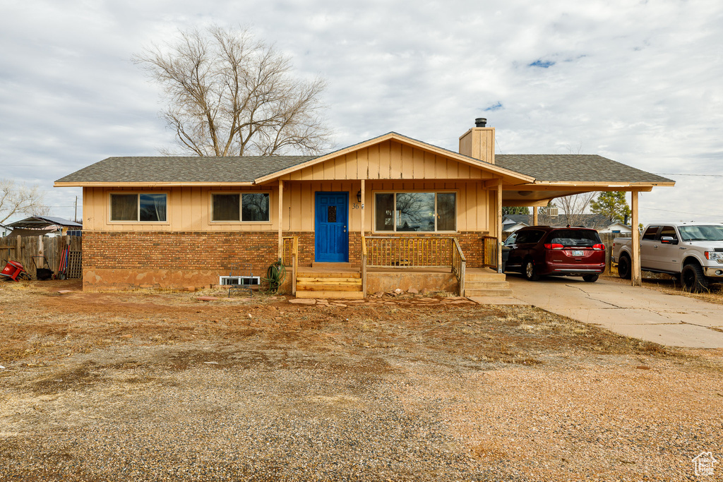Ranch-style home with covered porch and a carport