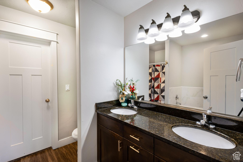 Bathroom featuring hardwood / wood-style floors, vanity, and toilet