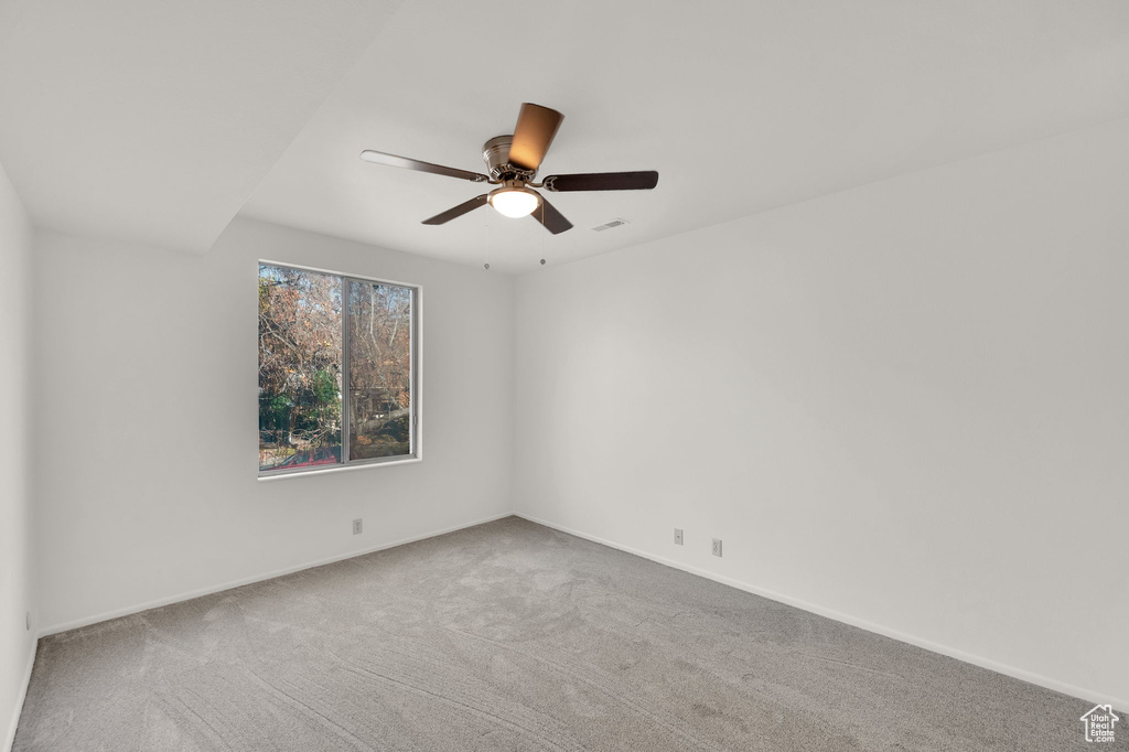 Carpeted spare room with ceiling fan