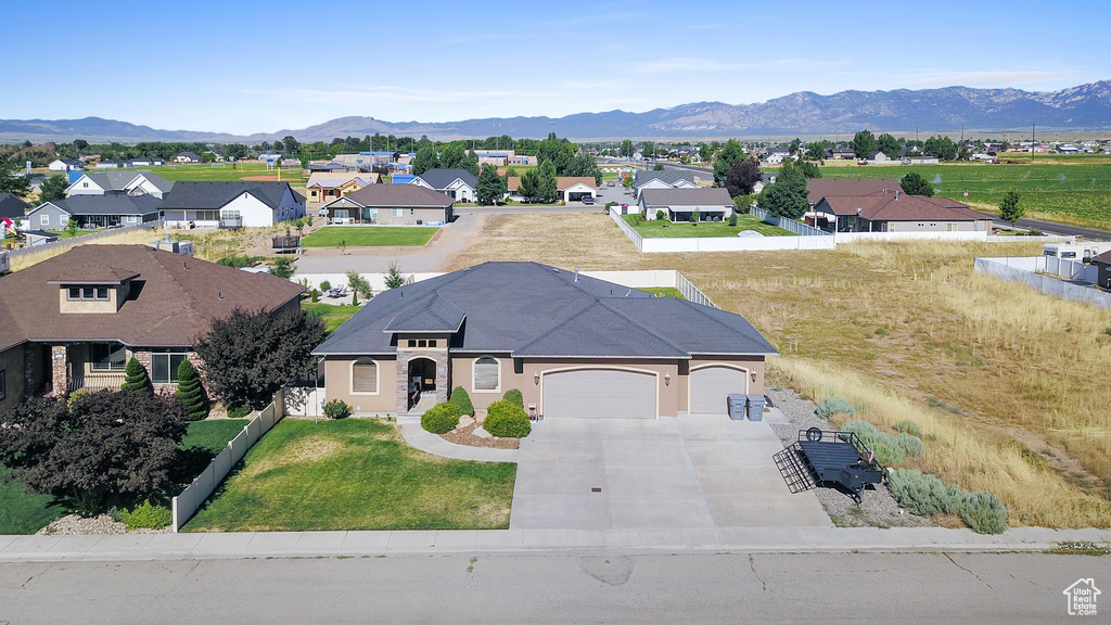 View of front of property featuring a mountain view, solar panels, and a garage