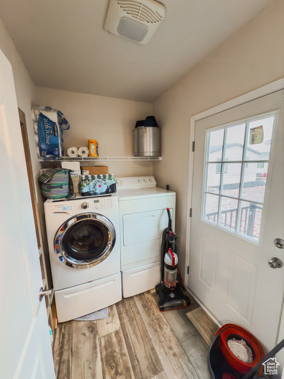 Washroom with separate washer and dryer and hardwood / wood-style flooring